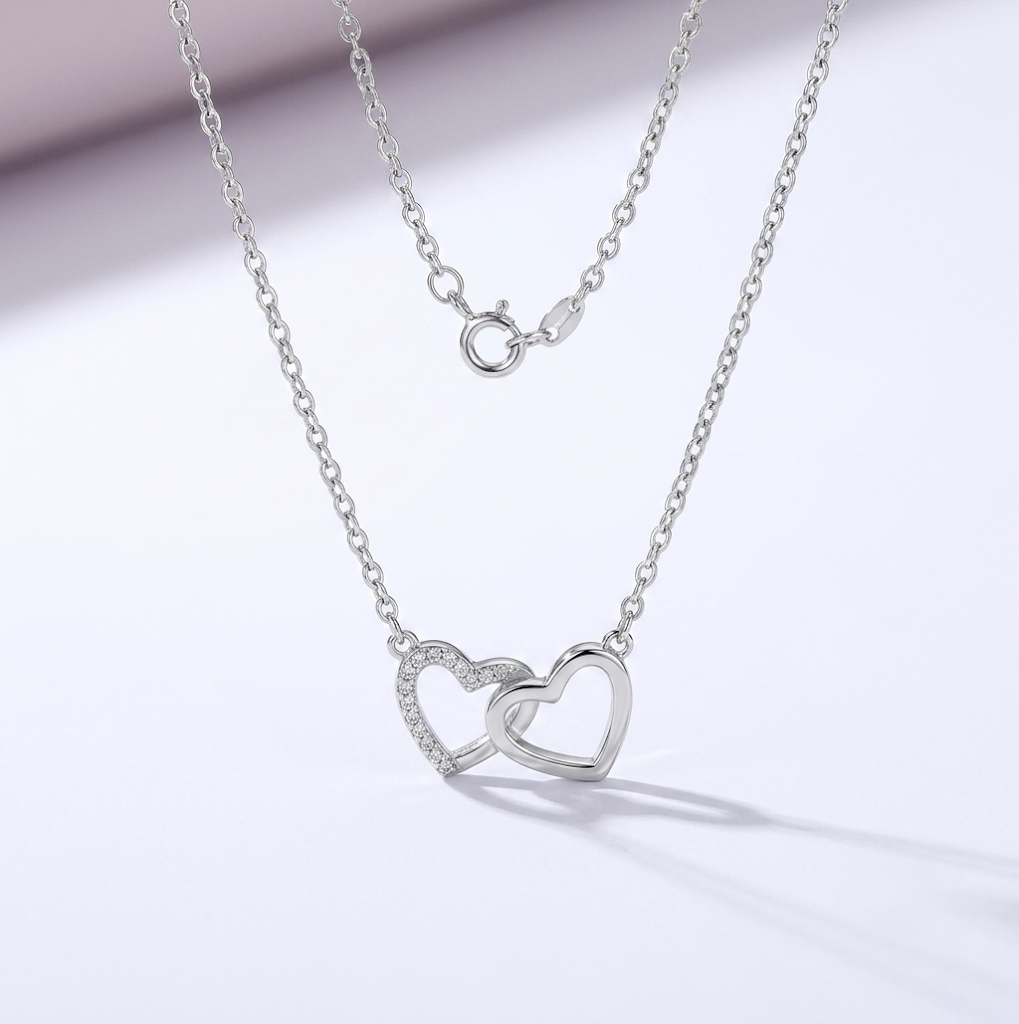 Unity — halsband med två sammanflätade hjärtan i silver, ena kantat av gnistrande stenar