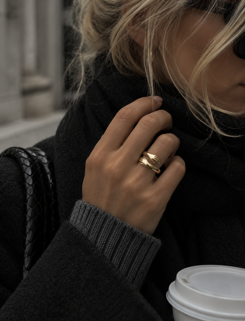 Närbild av Kram-ringen i guld i en vardagslook