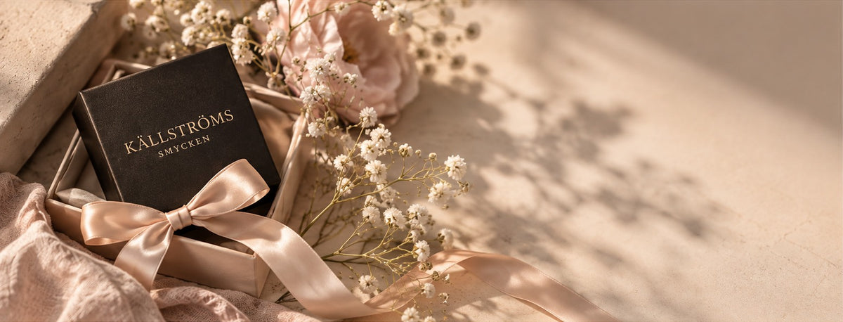 Källströms Smycken presentask med sidenband och blommor i varmt ljus